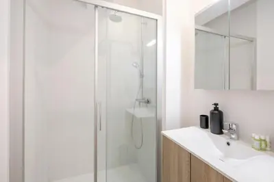 a white bathroom with a shower and a sink at THE GOOD FLATS in Brussels