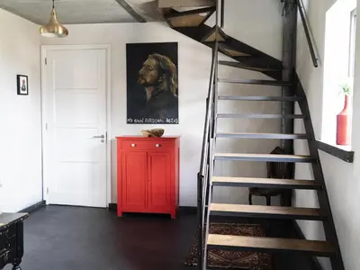 a staircase in a room with a red cabinet at De Lieshoeve in Arendonk