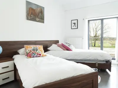a bedroom with two beds and a window at De Lieshoeve in Arendonk