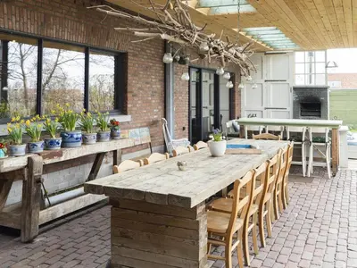 a patio with a large wooden table and chairs at De Lieshoeve in Arendonk
