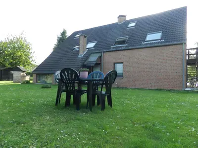 a table and chairs in the grass in front of a house at Résidences De Champles in Bierges