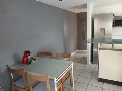 a kitchen with a white table and chairs and a table and a kitchen at Résidences De Champles in Bierges