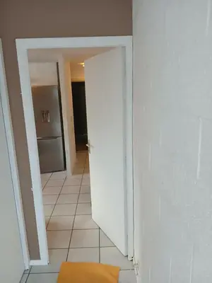 a hallway with a white door and a kitchen at Résidences De Champles in Bierges