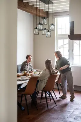 a group of people sitting around a dining room table at Beddermolen - Molenhuis op historisch erfgoeddomein in Westerlo