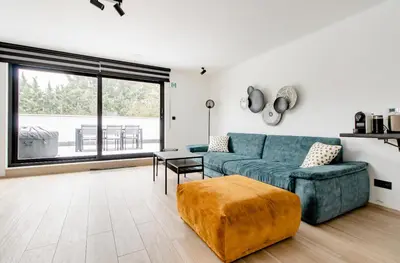 a living room with a blue couch and a table at Résidence Palace Expo in Brussels