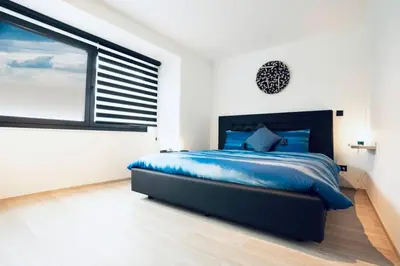 a bedroom with a blue bed and a large window at Résidence Palace Expo in Brussels