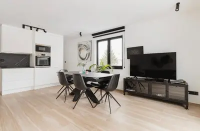 a living room with a table and chairs and a television at Résidence Palace Expo in Brussels