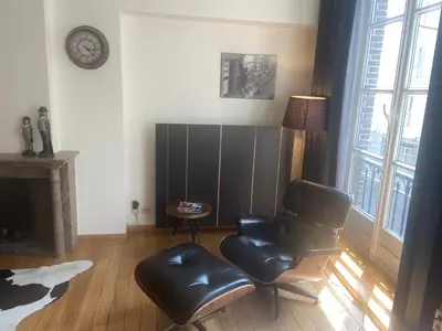a living room with a leather chair and a fireplace at Ghent Centre Croft Deluxe in Ghent