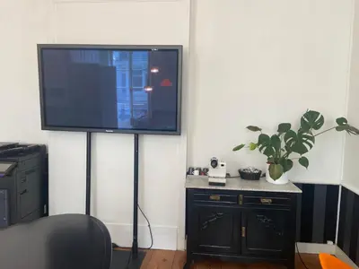 a flat screen tv on a stand in a room at Ghent Centre Croft Deluxe in Ghent