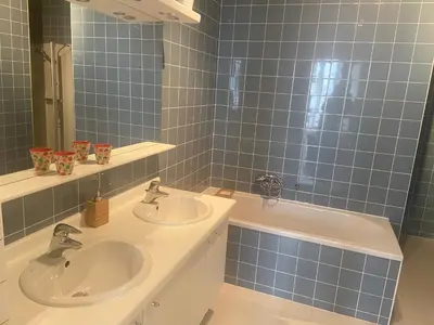 a bathroom with two sinks and a mirror and a tub at Ghent Centre Croft Deluxe in Ghent