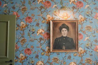 a painting of a man on a wall with flowers at Villa Servais in Halle