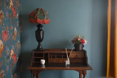 a table with a lamp and a plant on it at Villa Servais in Halle
