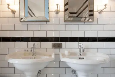 a bathroom with two sinks and mirrors on the wall at Villa Servais in Halle