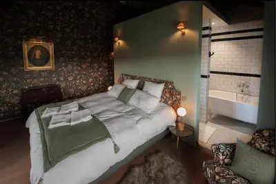 a bedroom with a large bed and a bath tub at Villa Servais in Halle