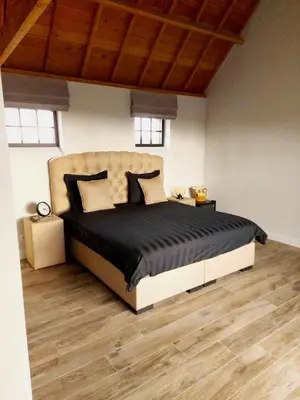 a bedroom with a large bed in a room with wooden floors at B&B Biesvenhof in Merksplas