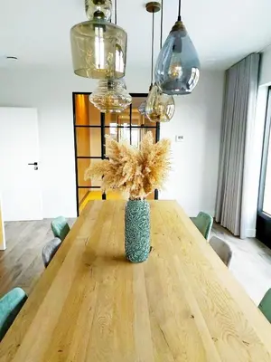a vase with flowers sitting on a wooden table at B&B Biesvenhof in Merksplas