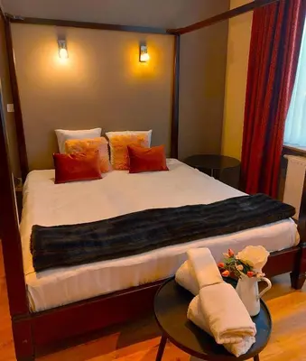 a bedroom with a large bed with pillows and a table at Mezonvin in Antwerp