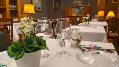 a table with wine glasses and flowers on it at Mezonvin in Antwerp