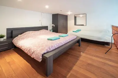 a bedroom with a large bed with blue towels on it at Saint Paulus Square Apartments in Antwerp