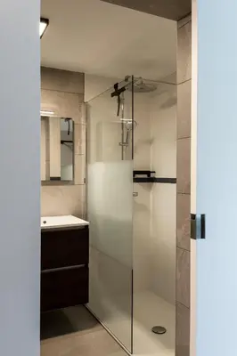 a glass shower in a bathroom with a sink at Guesthouse Max in Burcht