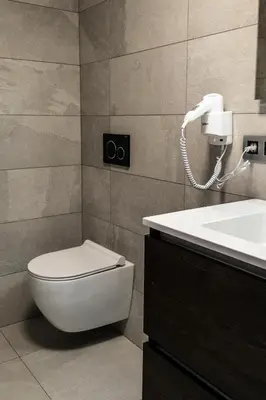 a bathroom with a toilet and a sink and a phone at Guesthouse Max in Burcht
