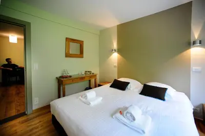 a bedroom with a large white bed with two pillows at B&B De Meren in Aarschot