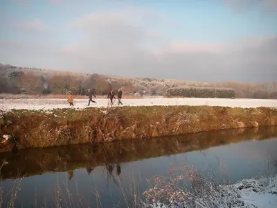 a group of people walking along a river at B&B De Meren in Aarschot