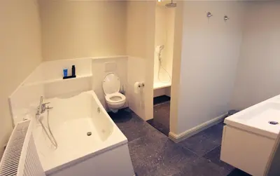 a bathroom with a tub and a toilet and a sink at Dendernachten in Dendermonde