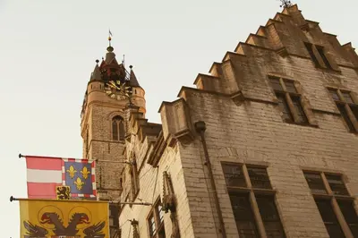 a building with a clock tower and a flag at Dendernachten in Dendermonde