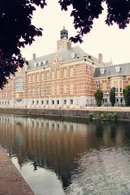 a large brick building next to a body of water at Dendernachten in Dendermonde