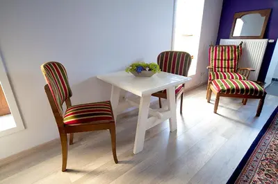 a white table with two chairs and a bowl of flowers on it at B&B t'Keygoed in Ghent