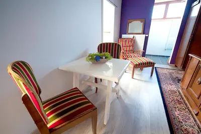 a room with a table and two chairs and a vase of flowers at B&B t'Keygoed in Ghent