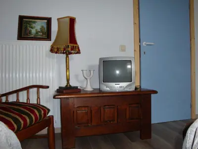 a room with a television on a dresser with a lamp at B&B t'Keygoed in Ghent