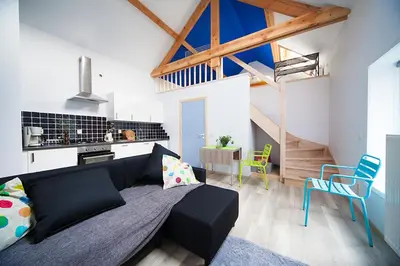 a living room with a black couch and chairs at B&B t'Keygoed in Ghent