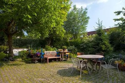 a patio with a table and chairs in a yard at B&B t'Keygoed in Ghent