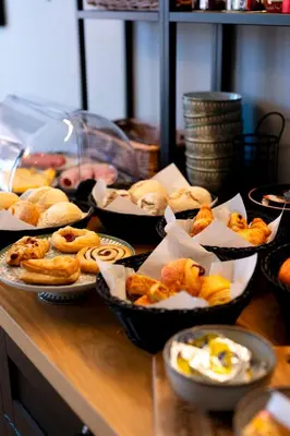 a table topped with bowls of pastries and other foods at B&B De Koepoort in Mechelen