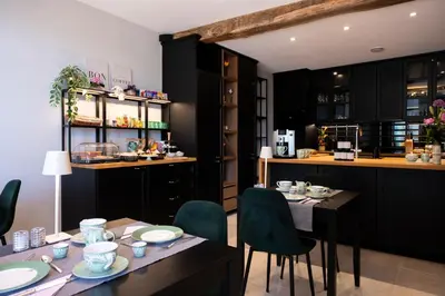 a kitchen and dining room with a table and chairs at B&B De Koepoort in Mechelen