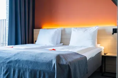 a hotel room with a bed with white sheets and pillows at Citybox Antwerp City Center in Antwerp