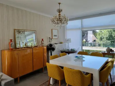a dining room with a white table and yellow chairs at Magnifique appartement- Brussels expo Laeken in Brussels