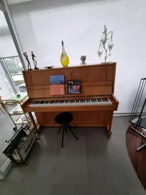 a wooden piano in a living room with a chair at Magnifique appartement- Brussels expo Laeken in Brussels