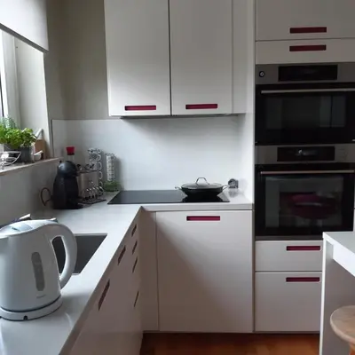 a kitchen with white cabinets and a stove top oven at Magnifique appartement- Brussels expo Laeken in Brussels
