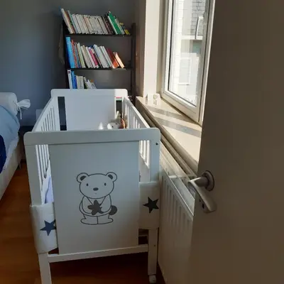 a white crib with a teddy bear stencil on it at Magnifique appartement- Brussels expo Laeken in Brussels