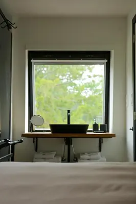 a bathroom with a sink in front of a window at Amand'eau - zwemvijver, zonneterras, grote tuin in Sint-Amands