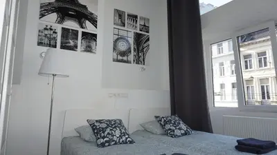 a bedroom with a bed and pictures on the wall at Roosevelt Apartments. in Antwerp