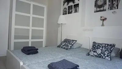 a bedroom with a bed with blue sheets and pillows at Roosevelt Apartments. in Antwerp