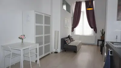 a living room with a table and a chair at Roosevelt Apartments. in Antwerp