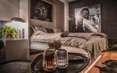 a bedroom with a bed with a table and a poster at Backstage in Haacht