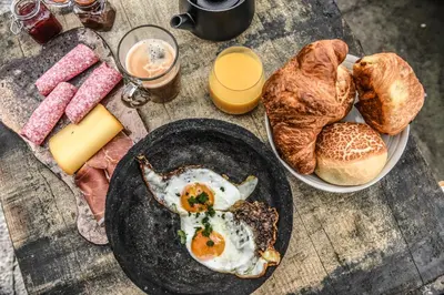 a table with a plate of eggs and bread at Backstage in Haacht