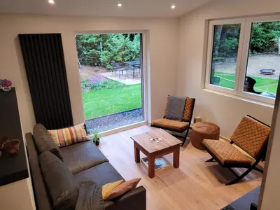a living room with a couch and chairs and a window at Hogenberg Heiken Lichtaart Kasterlee met eigen laadpaal in Lichtaart