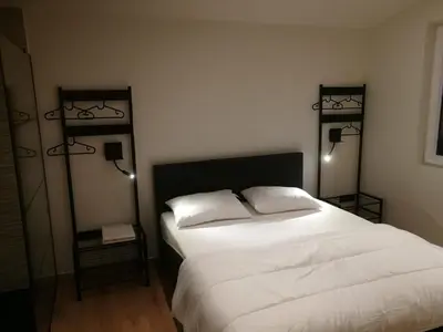 a bedroom with a large white bed with two lamps at Hogenberg Heiken Lichtaart Kasterlee met eigen laadpaal in Lichtaart